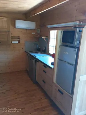 a kitchen in a log cabin with a refrigerator and a sink at Grand Chalet at Villa Don Quijote Nice in Nice