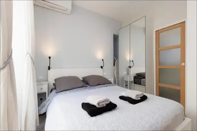 a bedroom with a white bed with towels on it at 1 bed, center of Nice with AC in Nice