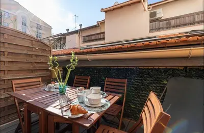 a wooden table on a balcony with chairs and a tableasteryasteryasteryasteryastery at 1 bed, center of Nice with AC in Nice