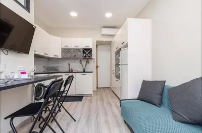 a living room with a blue couch and a kitchen at 1 bed, center of Nice with AC in Nice