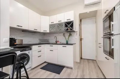 a white kitchen with white cabinets and a sink at 1 bed, center of Nice with AC in Nice
