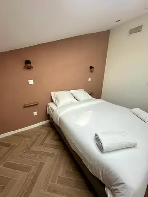 a large white bed in a room with a wall at GIOFFREDO SUITE in Nice