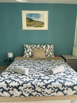 a bedroom with a bed with a blue wall at Nice modern flat in Nice