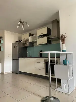 a kitchen with a refrigerator and a table in it at Nice modern flat in Nice