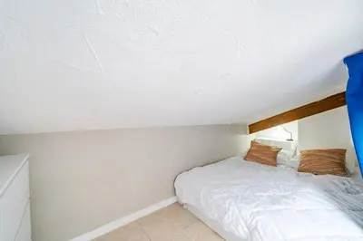 a small bedroom with a bed in a attic at Cosy studio proche Gare de Nice in Nice
