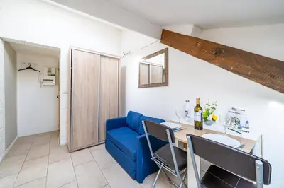 a living room with a blue couch and a table at Cosy studio proche Gare de Nice in Nice