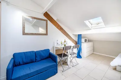 a living room with a blue couch and a table at Cosy studio proche Gare de Nice in Nice