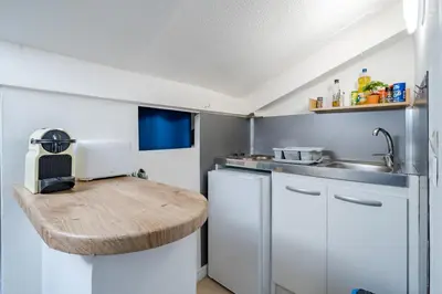 a kitchen with a wooden counter top and a sink at Cosy studio proche Gare de Nice in Nice