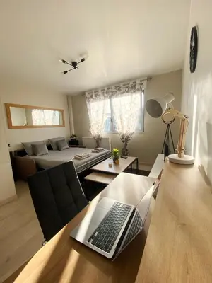 a living room with a table with a laptop on it at Bel Appartement 2 pièces - 10min de la mer in Nice