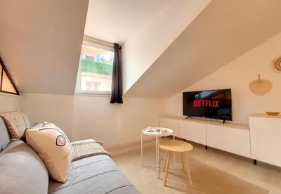 a living room with a couch and a tv at Nestor&Jeeves - VIEUX NICE SUITE - Studio - Centre in Nice