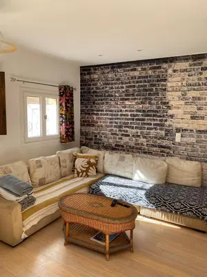 a living room with a couch and a brick wall at Maison de ville avec jardin in Nice
