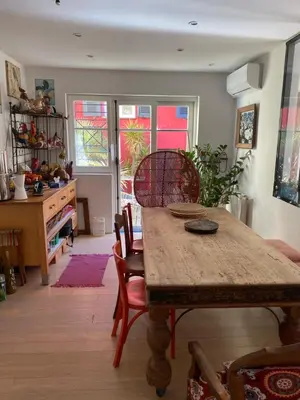 a dining room with a wooden table and chairs at Maison de ville avec jardin in Nice