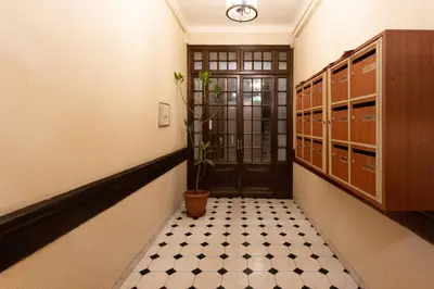 a hallway with a black door and a black and white floor at GIOA- Studio avec balcon, place Garibaldi -Paillon in Nice
