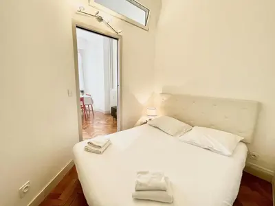 a bedroom with a white bed and a mirror at Belle Nuit in Nice