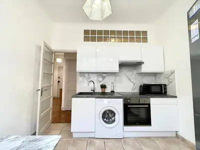 a kitchen with white cabinets and a washer at Belle Nuit in Nice