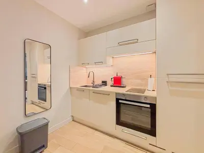 a kitchen with white cabinets and a sink and a mirror at Petit cocon au cœur du Vieux-Nice, Wifi, AC, 2pers in Nice