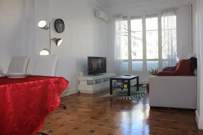 a living room with a couch and a tv on a wall at LE REX Nice in Nice