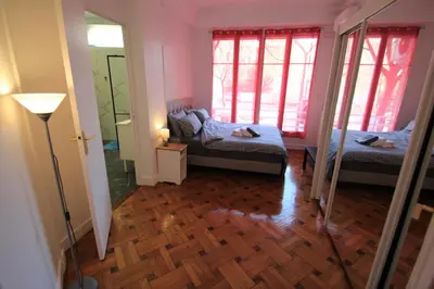 a small room with two beds and a mirror at LE REX Nice in Nice