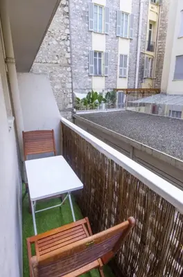 a balcony with two chairs and a table and a white table at Charmant studio rue Hérold - Wifi, AC, 2pers in Nice