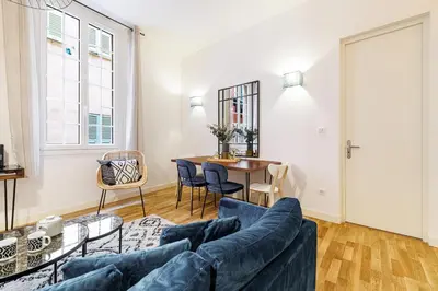 a living room with a blue couch and a table at Chic & Cozy 2 Bdr Heart of the Old Town in Nice