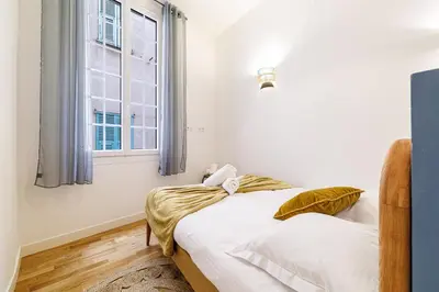 a bedroom with a bed and a window at Chic & Cozy 2 Bdr Heart of the Old Town in Nice