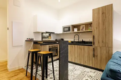 a kitchen with white cabinets and bar stools at Chic & Cozy 2 Bdr Heart of the Old Town in Nice
