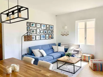 a living room with a blue couch and a table at Nice Sea View 2 bedroom apartment in Nice