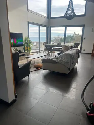 a living room with a couch and a table and windows at Villa location saisonniere in Nice