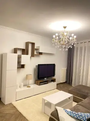 a living room with a television and a chandelier at Appart T2 refait à neuf 50m2 in Nice
