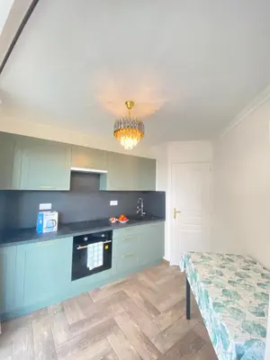 a kitchen with blue cabinets and a table in it at Appart T2 refait à neuf 50m2 in Nice