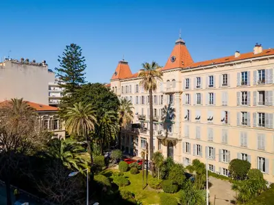 a large building with palm trees in front of it at Nice Renting - VICTOR - Historic Palace Luxury 3 Bedrooms in Nice