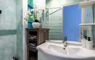 a bathroom with a sink and a mirror at Iconic Central Flat in Nice