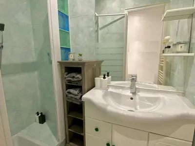 a white bathroom with a sink and a shower at Iconic Central Flat in Nice