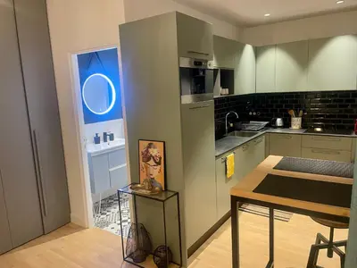 a kitchen with green cabinets and a table and a window at Suite ana in Nice