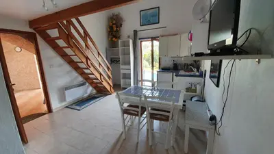 a kitchen with a table and chairs in a room at Studio-mezzanine dans villa in Cagnes-sur-Mer