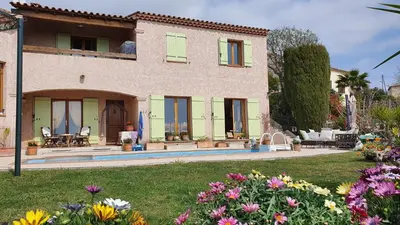 a large house with a yard with flowers at Studio-mezzanine dans villa in Cagnes-sur-Mer