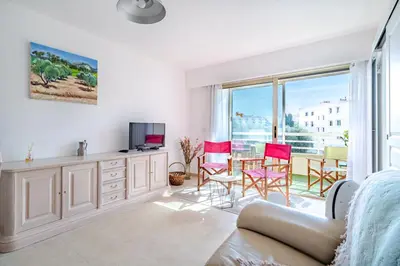 a living room with a couch and a table and chairs at 2 pièces Calme Proche de la mer Parking en sous-sol in Cagnes-sur-Mer
