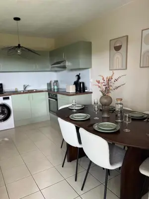 a kitchen with a wooden table and white appliances at Nice french Riviera, parking gratuit, Tram L1 AU PIED de l'immeuble in Nice