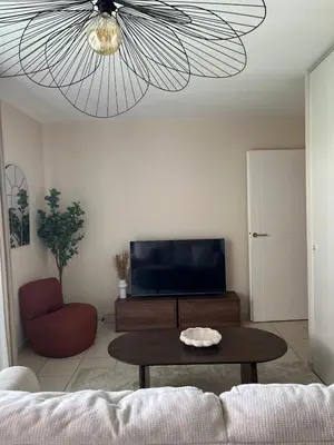a living room with a table and a ceiling fan at Nice french Riviera, parking gratuit, Tram L1 AU PIED de l'immeuble in Nice