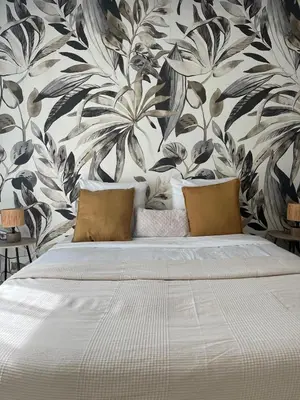 a bedroom with a large bed with a floral wallpaper at Nice french Riviera, parking gratuit, Tram L1 AU PIED de l'immeuble in Nice