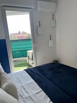 a bedroom with a bed and a sliding glass door at Nice french Riviera, parking gratuit, Tram L1 AU PIED de l'immeuble in Nice