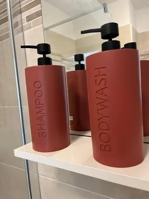 a row of red shampoo bottles on a shelf at Nice french Riviera, parking gratuit, Tram L1 AU PIED de l'immeuble in Nice