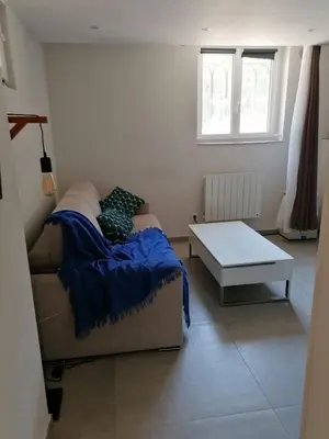 a bedroom with a couch and a table in it at Joli studio à Nice in Nice