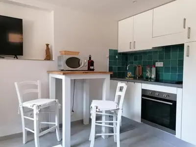 a kitchen with two white stools and a microwave at Joli studio à Nice in Nice