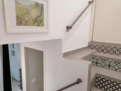 a stairwell with a framed picture and a white wall at Joli studio à Nice in Nice
