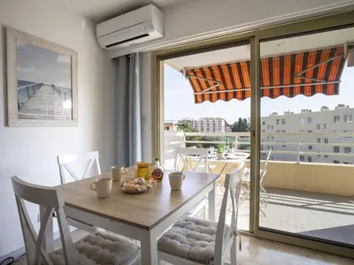 a dining room with a table and a view of a balcony at Apartment Cagnes Provencal by Interhome in Cagnes-sur-Mer