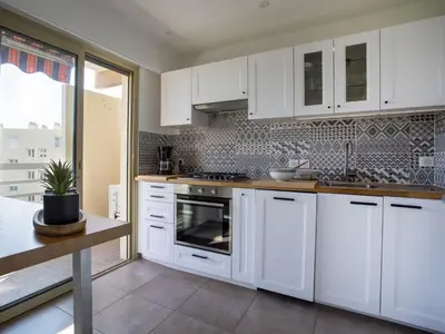 a white kitchen with white cabinets and a sink at Apartment Cagnes Provencal by Interhome in Cagnes-sur-Mer