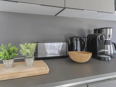 a kitchen counter with a coffee maker and some plants at Apartment Prestige view by Interhome in Èze
