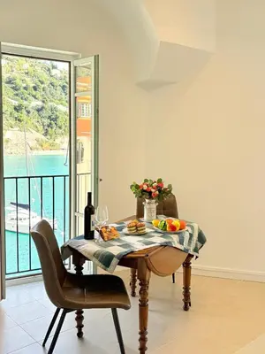 a table with a bowl of fruit and a bottle of wine at NEPTUNE AP4453 By Riviera Holiday Homes in Villefranche-sur-Mer