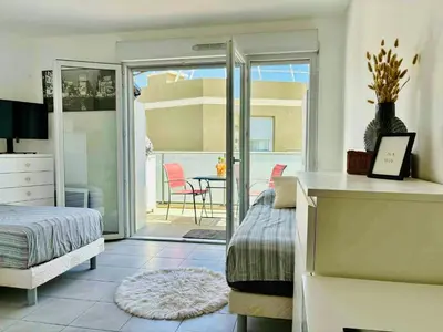 a bedroom with a bed and a sliding glass door at Cosy Apartment Vauban in Nice